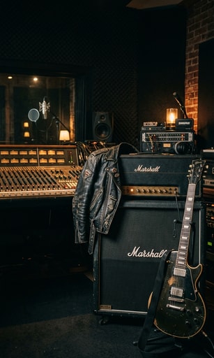 Moody recording studio with vintage guitar, amplifier, and leather jacket anticipating a new rock album.