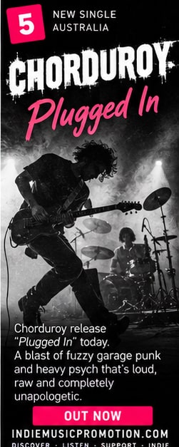Black and white action shot of Chorduroy guitarist jumping on stage for Plugged In.